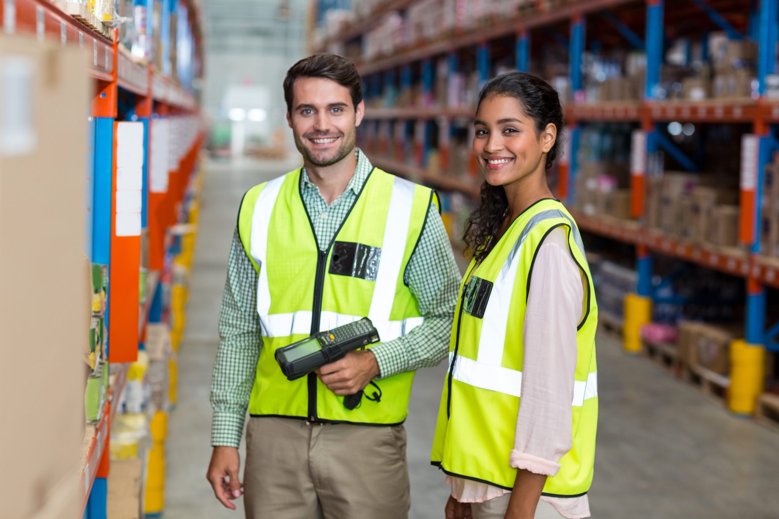 Portrait of smiling warehouse workers scanning box